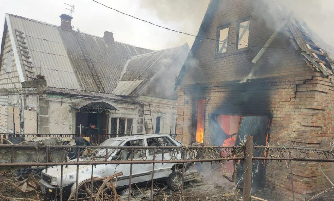Пожежа в цегляному будинку, згоріле авто та дим за парканом